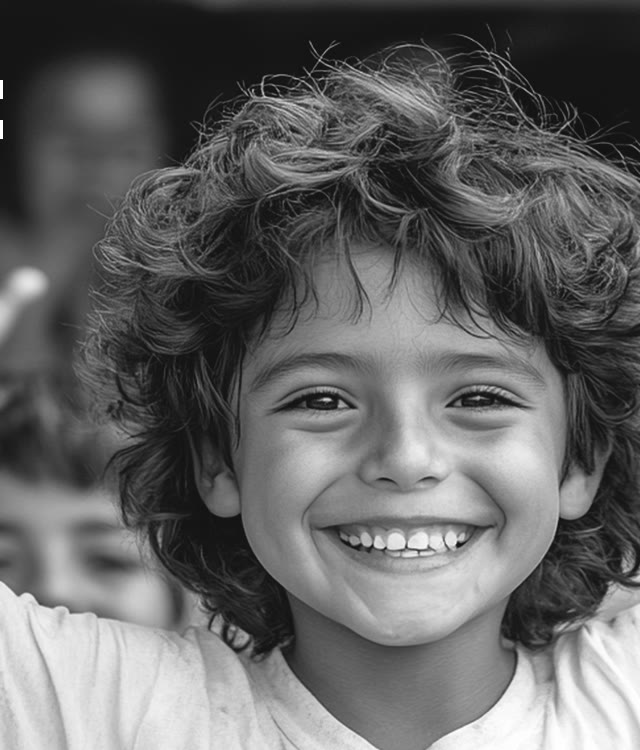 Un niño sonriendo con los brazos en alto